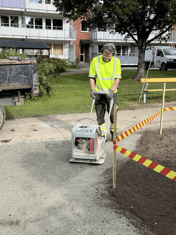 Gångväg av grus som packas med markvibrator